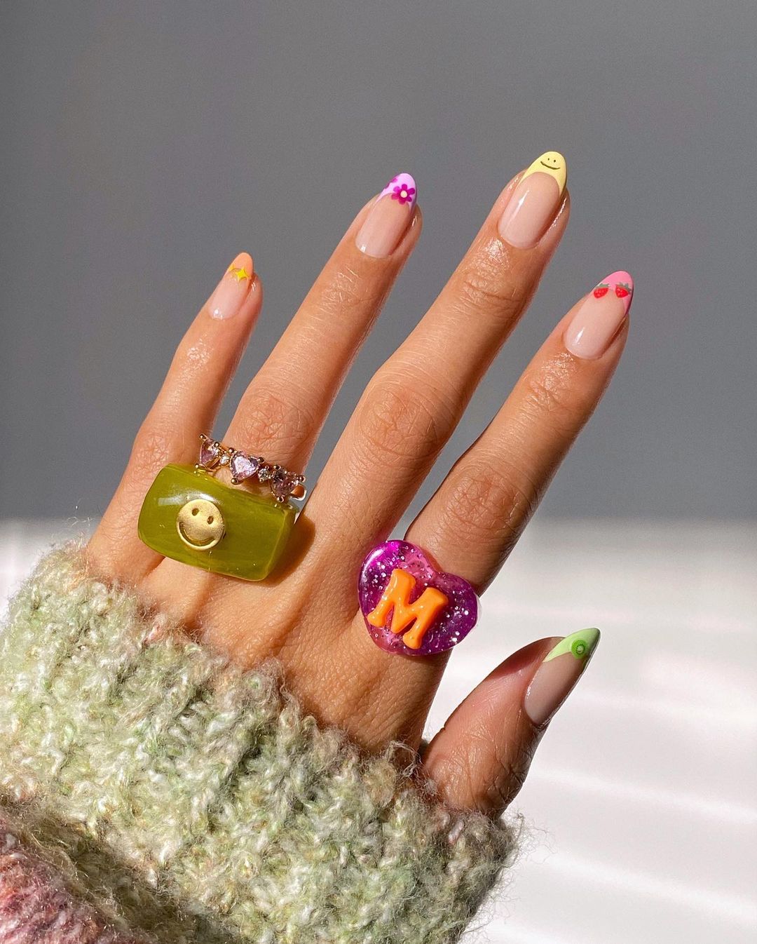 Manicura francesa con flores, frutas y otros motivos. La clásica manicura francesa se puede combinar con otros diseños más veraniegos como las frutas, las flores, los emoticonos o las estrellas. El resultado no puede ser más refrescante y original.