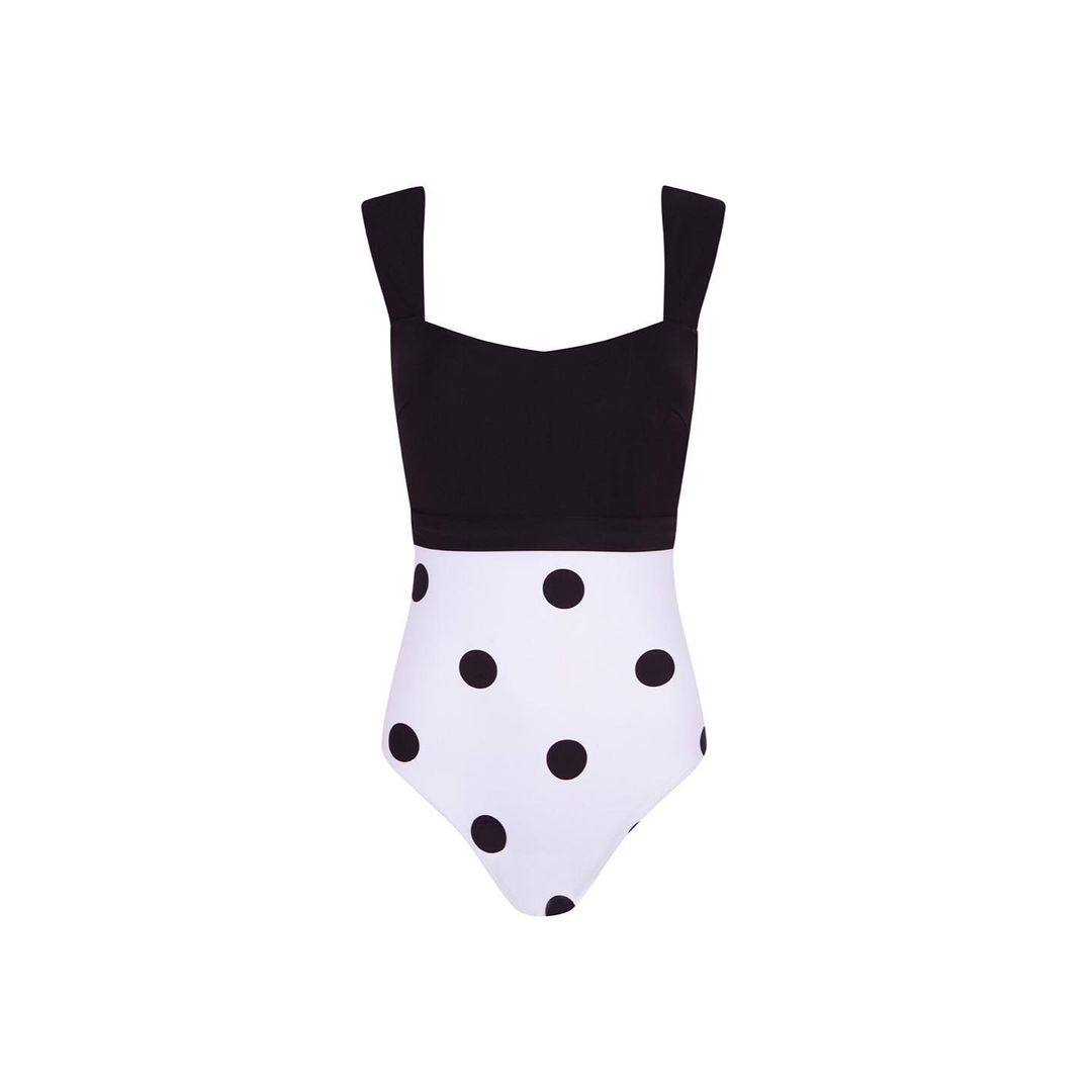 Alawa reinventa la moda ochentera con bañadores de dos partes con distinto diseño. Este concretamente  tiene grandes lunares negros sobre fondo blanco en la parte de abajo, siendo un elemento atemporal al que siempre se puede recurrir. Su parte de arriba es completamente negra de tirantes anchos que destaca la silueta. Con un precio de 180€.