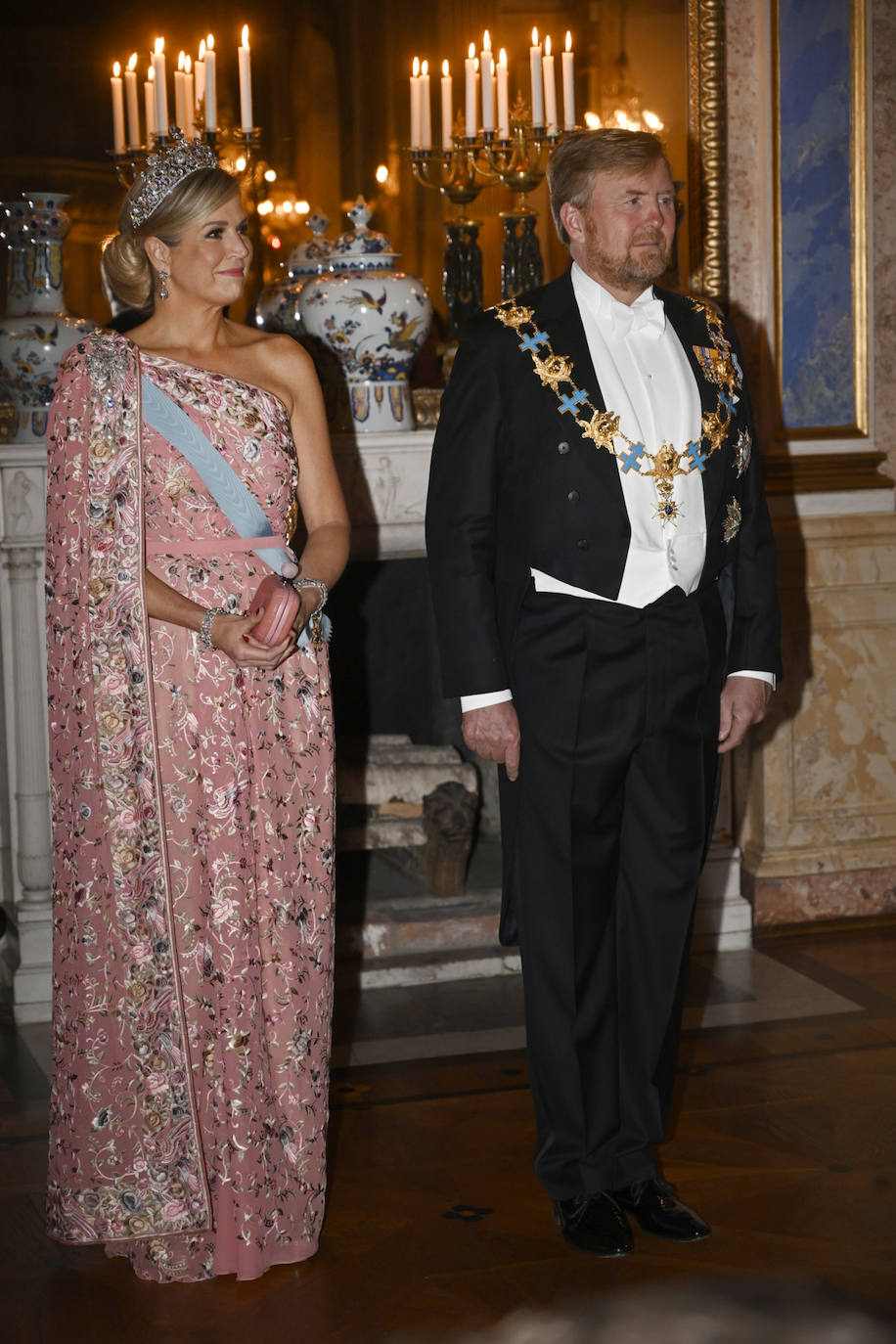 Por la noche, en la cena de gala, celebrada en el Palacio Real de Estocolmo, Máxima de Holanda elegía un vestido de fiesta que estrenó en 2019 durante un viaje oficial a la India. Diseñado por Jan Taminiau, su diseñador de referencia, es un vestido rosa empolvado adornado con bordados florales en tonos pastel. Lo ha combinado con una de las joyas más importantes de su joyero, la tiara Stuart, compuesta por 900 diamantes, y que perteneció a la bisabuela del rey, la reina Guillermina.