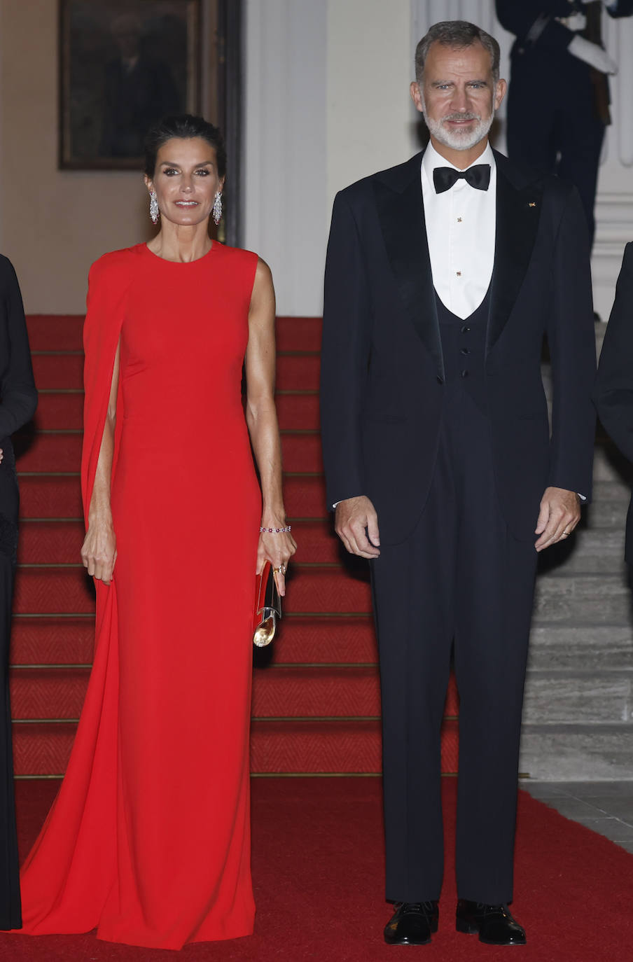 En la cena de gala, celebrada en el palacio de Bellevue, doña Letizia optaba por el vestido rojo de Stella McCartney que estrenó por el 50º cumpleaños del rey Guillermo de Holanda. Un diseño muy elegante con capa, escote redondo y sin mangas que dejaban al descubierto los fibrosos brazos de la reina. Lo combinó con sandalias doradas de Jimmy Choo de tacón alto.