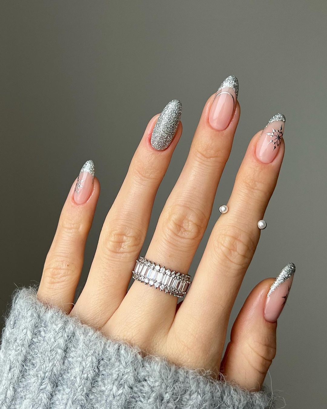 La manicura plateada también es una buena elección para las navidades. En este caso en casa uña se ha elegido un diseño diferente. 