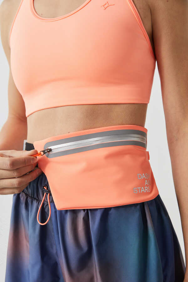 Riñonera técnica, ligera y extra plana (para un mejor ajuste) de color naranja flúor. Con práctico cinturón elástico y regulable. 14,99 euros en Dash and Stars.