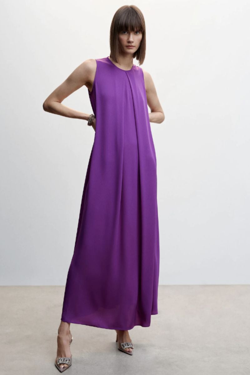 Diseño evasé de Mango en color púrpura con manga sisa y cuello redondo con el largo hasta los pies. Un vestido que hará las delicias de las que no quieren renunciar a la comodidad sin perder el estilo y que cobra un sentido completamente diferente si se le añade un accesorio XXL. Precio: 39,99 €.