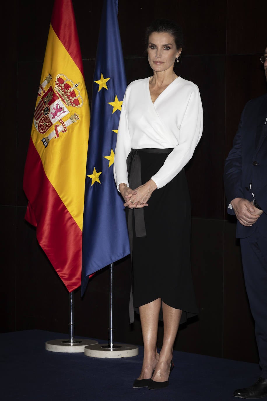 El martes por la tarde, los reyes acudían a la inauguración de la exposición de Joan Miró. Para este ocasión la reina estrenaba un elegante conjunto compuesto por blusa blanca de escote cruzado y falda negra con lazo en la cintura, que combinaba con salones destalonados y cartera de Carolina Herrera, también en color negro. Lo más llamativo del look ha sido su peinado y maquillaje.