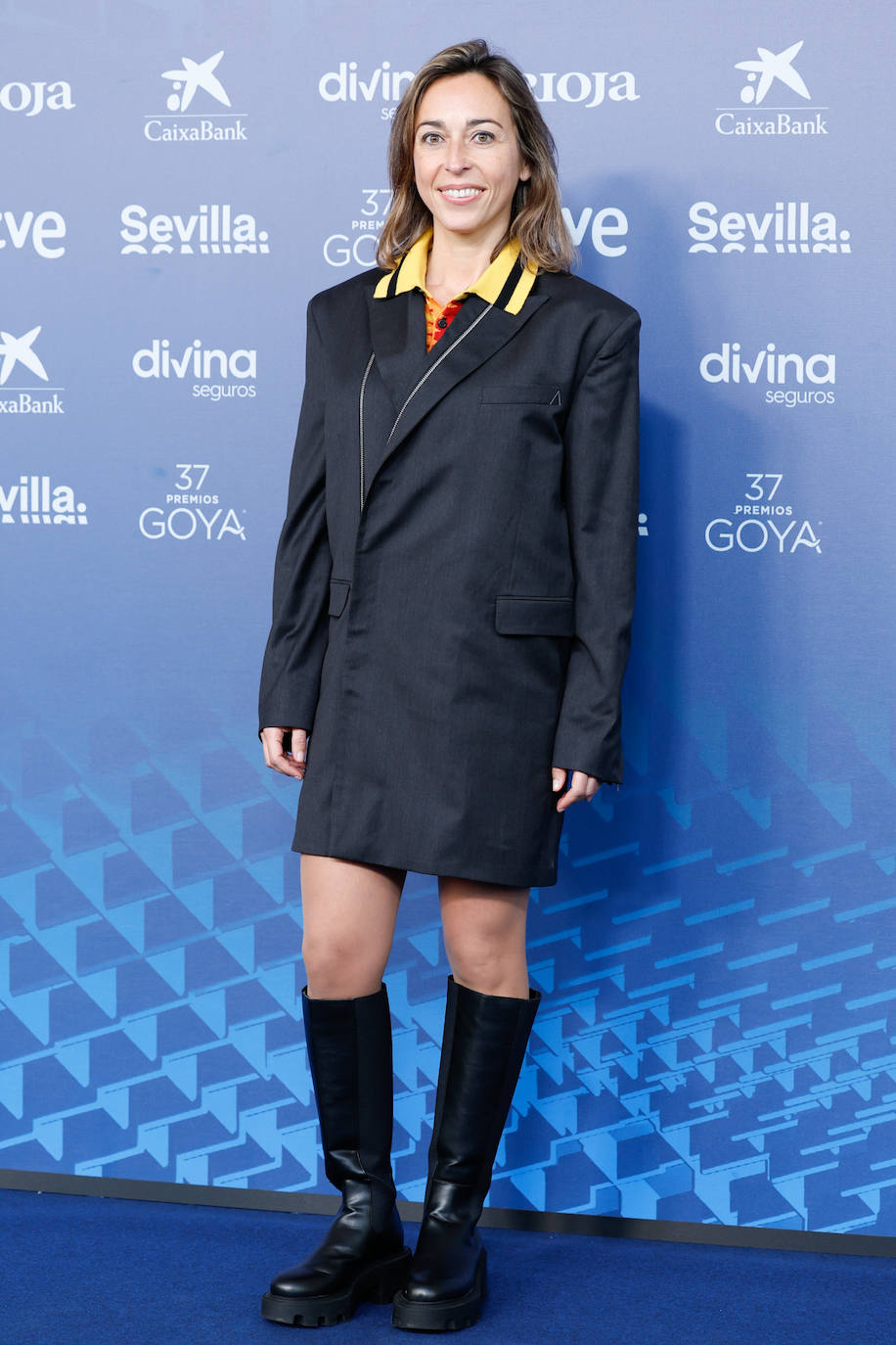 La directora de cine Denise Castro con vestido-blazer y botas track altas. 