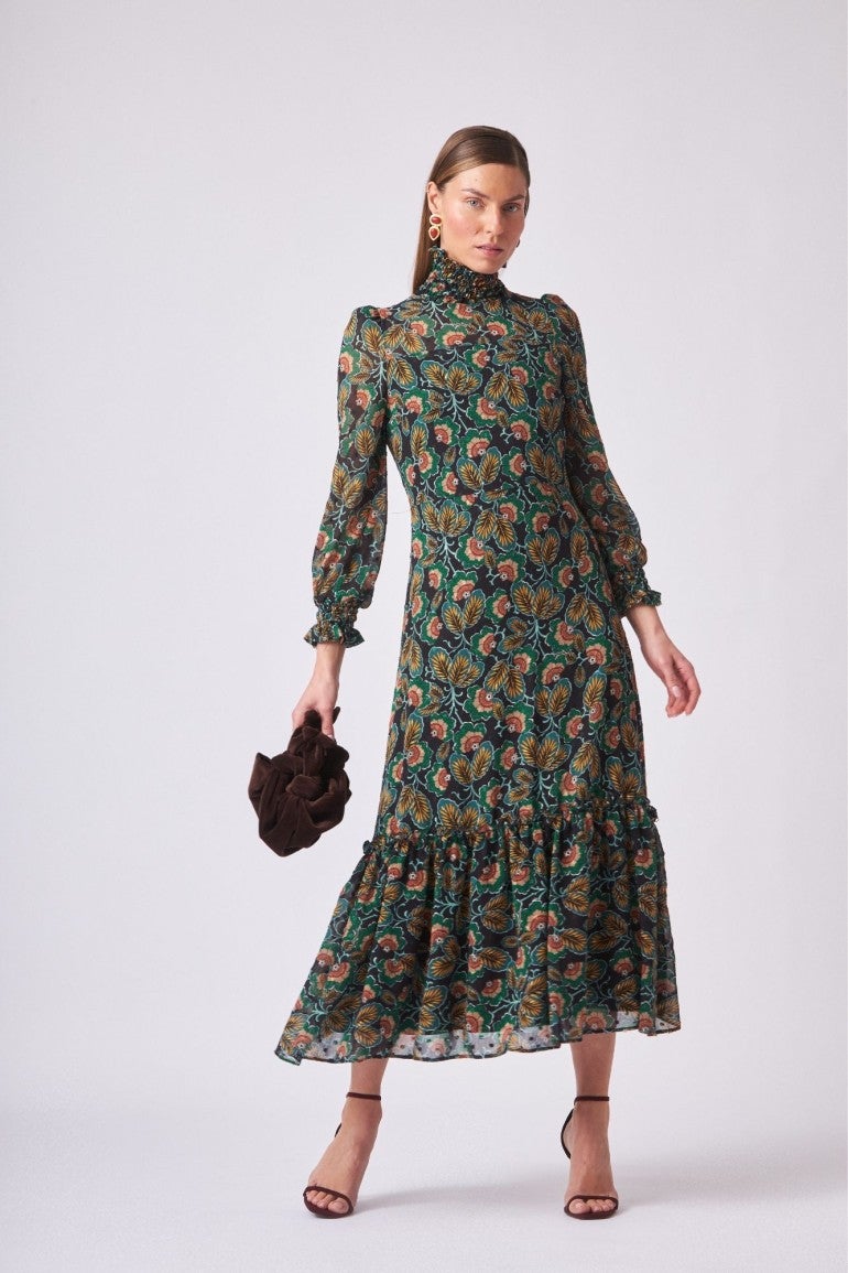 Vestido fluido confeccionado en gasa con estampado verde y amarillo, con cuello alto con elástico y manga larga y cierre trasero con botones en el cuello. 89 euros en Coosy.