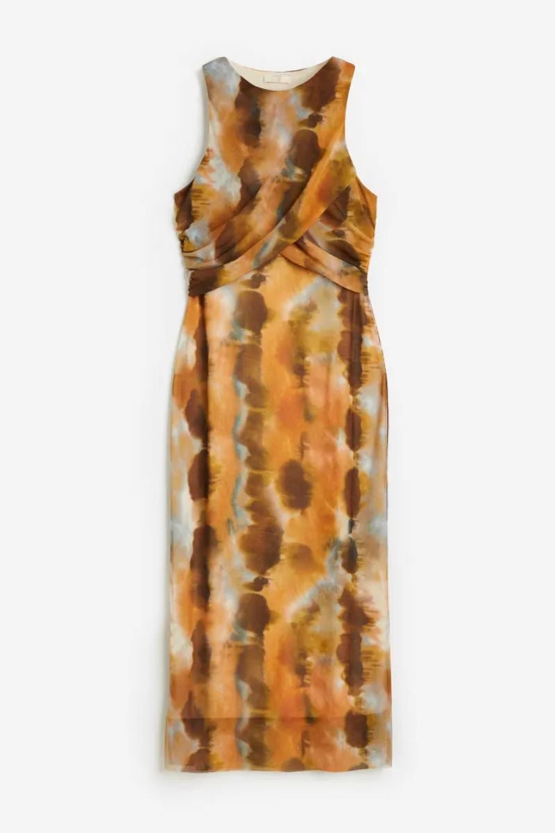 Tonos tierra. Vestido midi de malla con print arty, de H&M. Un diseño con escote redondo, tirantes anchos cruzados en la parte frontal y costuras laterales fruncidas para crear un ligero efecto drapeado. Precio: 39,99€.