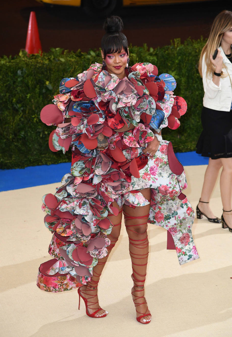 Rihanna en la Gala Met 2017 con un original diseño de Comme des Garçons, formado por pétalos y volantes en tonos rojos, que combinó con sandalias de tiras del mismo tono y un maquillaje también en tonos rojizos. 