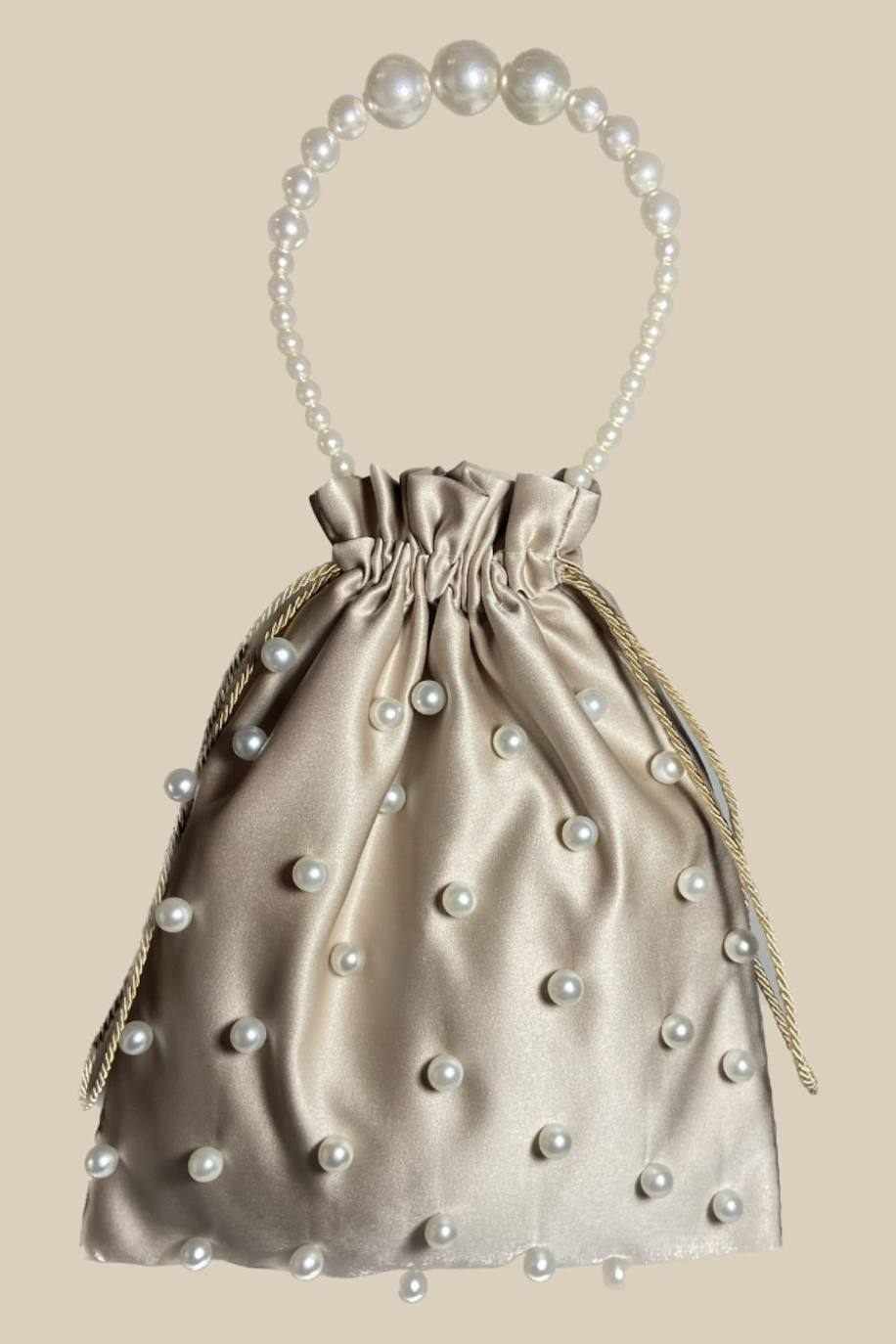 Bolso metalizado en color 'nude', decorado con con perlas. 49.99 euros en Vilba Bags. 