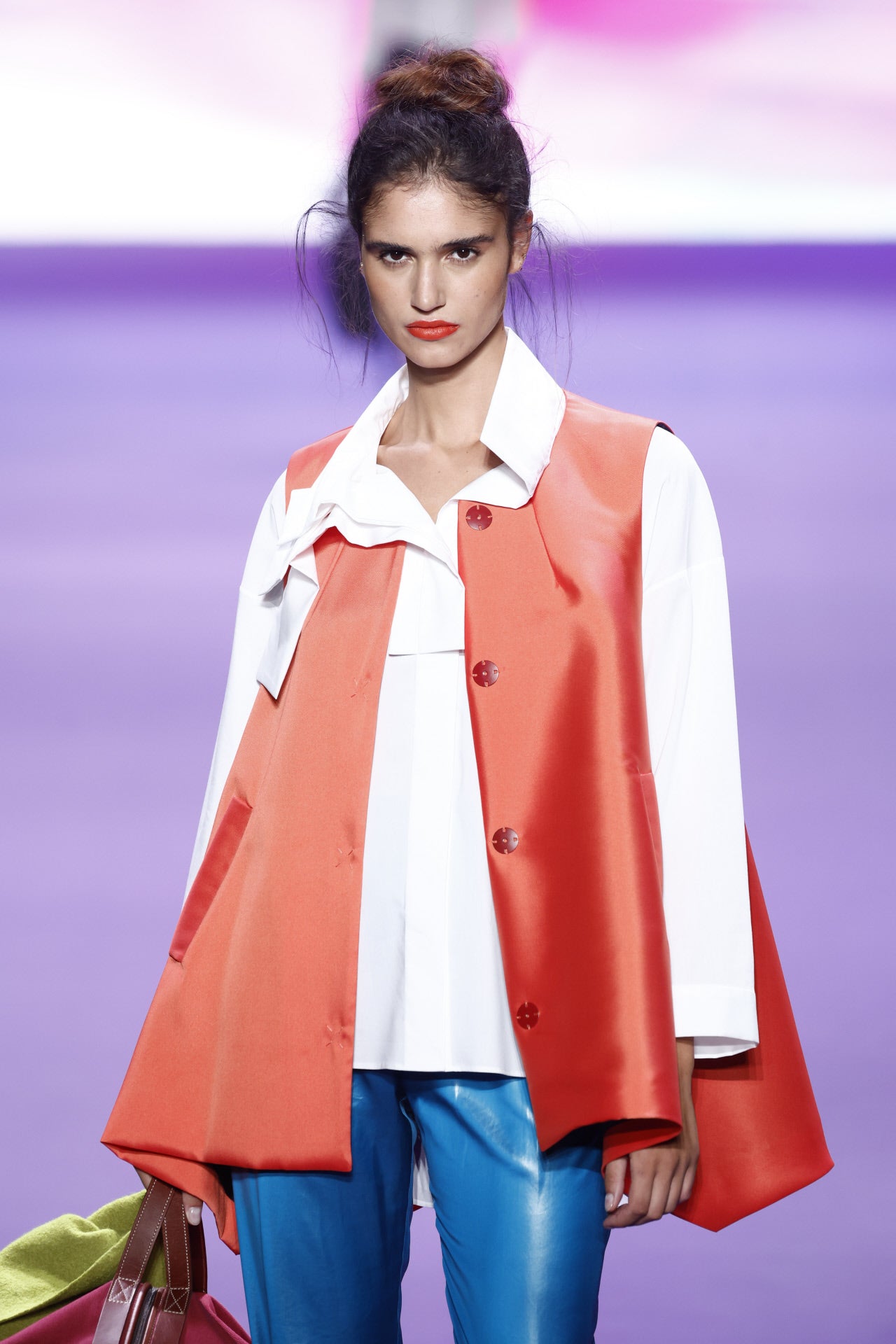 La superposición de prendas con grandes cuellos con acabado en lazada asimétrica define a una mujer que viaja ligera de equipaje. 