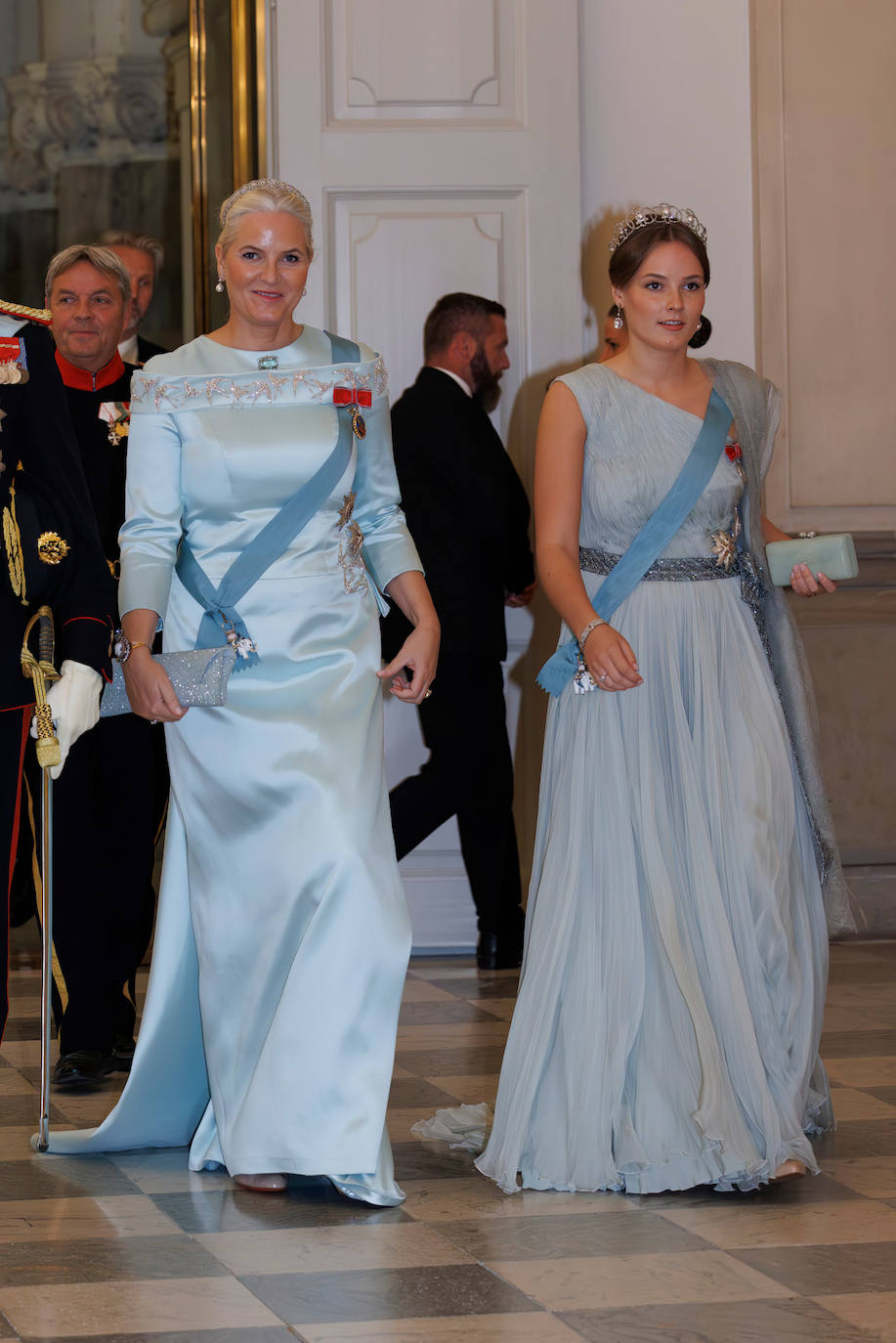 La princesa Mette-Marit de Noruega lució un vestido azul bebé de Peter Dundas, a juego con un clutch del mismo tono, y zapatos Louboutin en nude. También recogió su melena para lucir una tiara. Por su parte, su hija, la princesa Ingrid eligió un vestido vaporoso también azul, con  bolso a juego y zapatos nude.