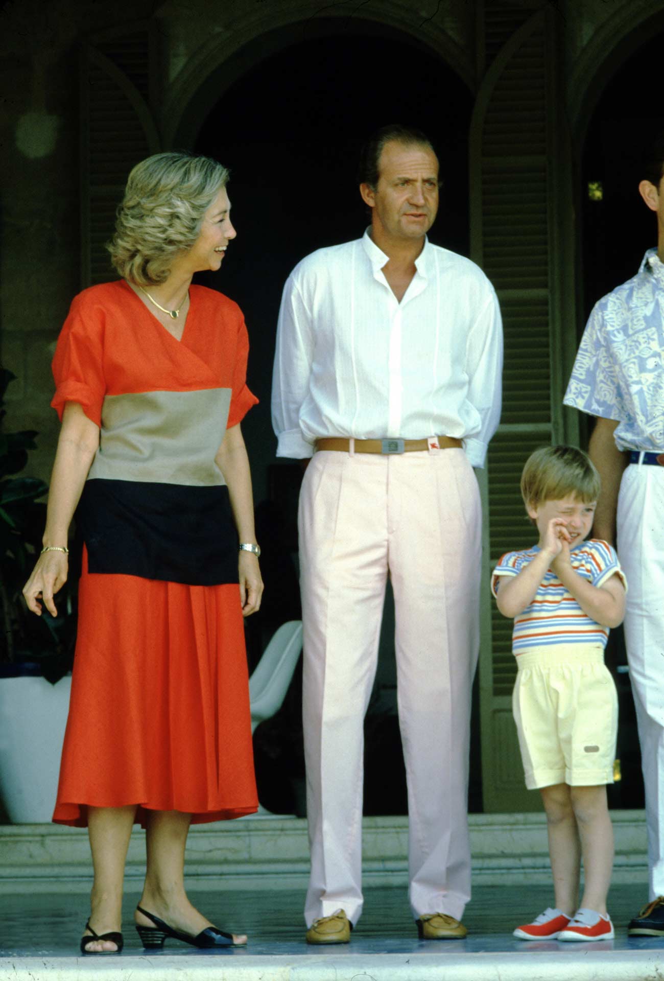 Para uno de sus viajes a Palma de Mallorca, en este junto a la Familia Real inglesa, eligió un vestido de corte midi, con mangas tres cuartos y en color rojo. En el cuerpo del diseño, un fajín en tono beige y negro. 