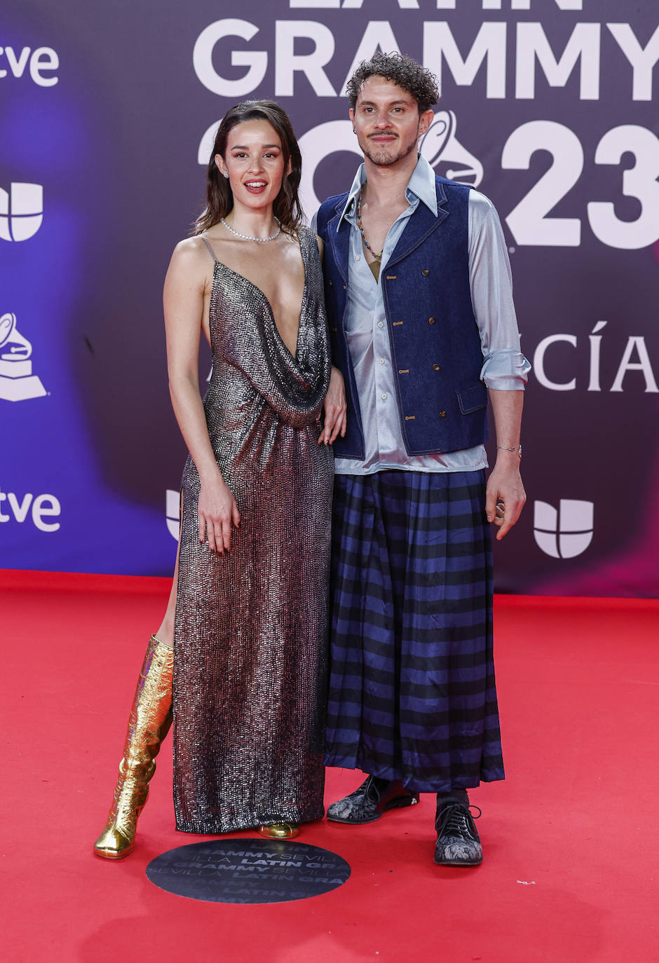 Un invitado con falda de cuadros, que ha combinado con camisa y chaleco tejado. 