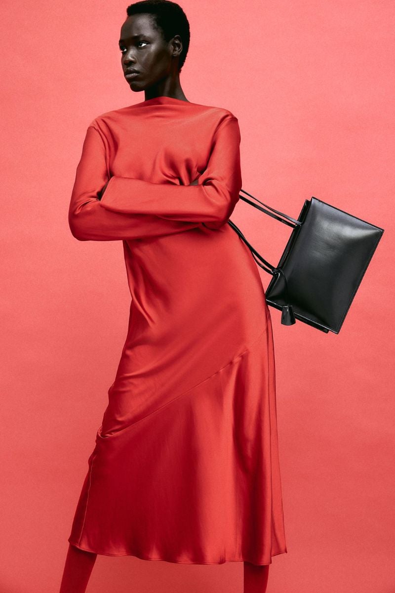 H&M. Vestido midi rojo en tejido fluido de satén con escote drapeado y abertura con tiras finas. Para las que buscan un look con carácter propio. Precio: 39,99€.