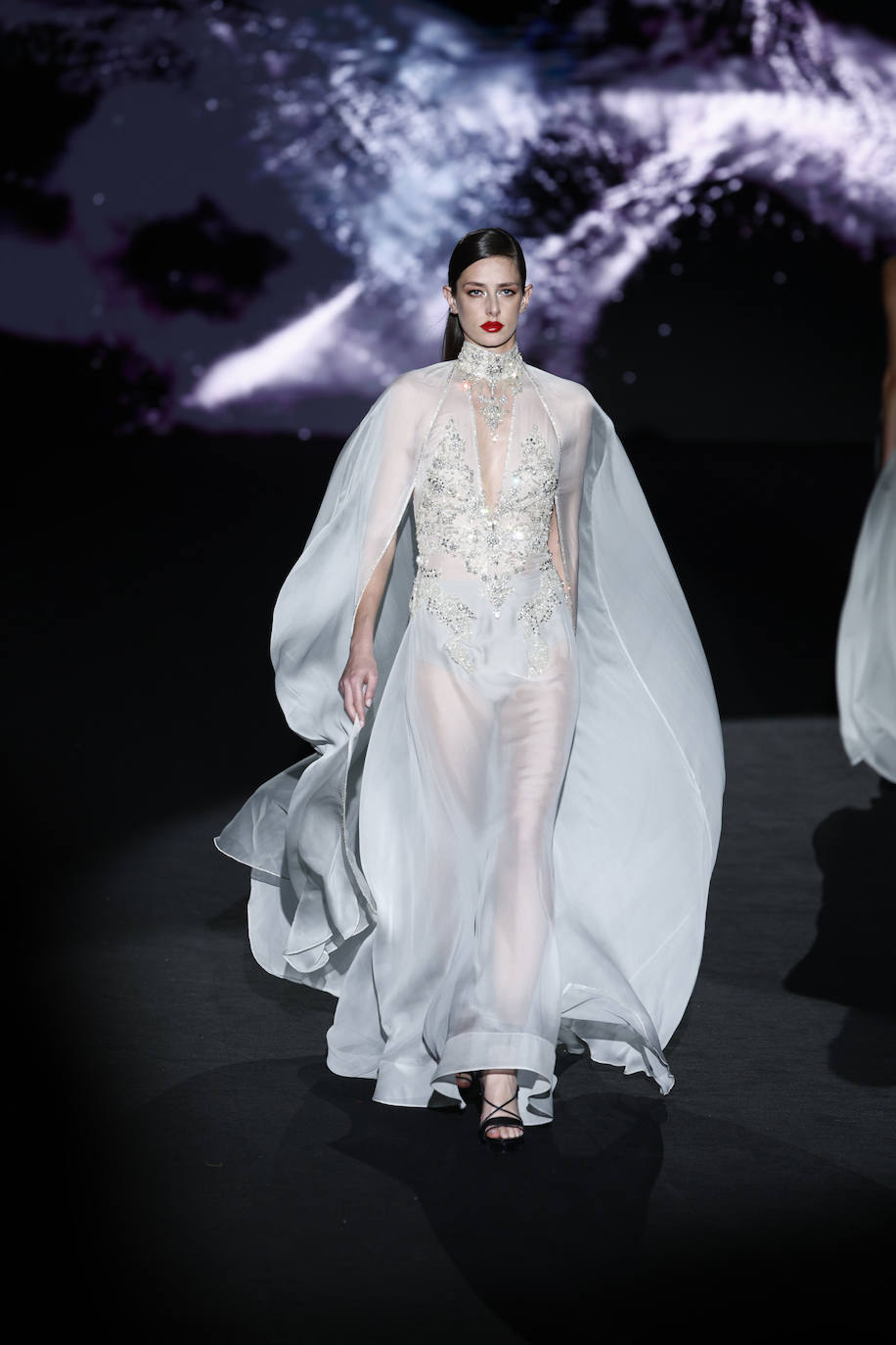 Vestido transparente con capa incorporada que mezcla la seda y los detalles de pedrería. 