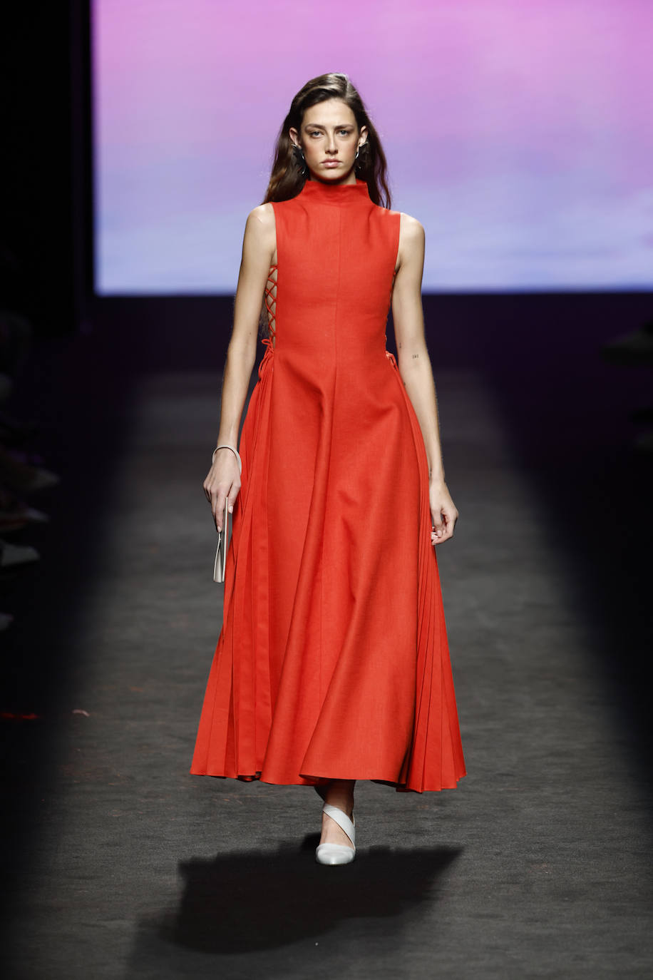 Vestido naranja con falda amplia y aberturas en los laterales de la colección de otoño/invierno 2024 de Isabel Núñez. 