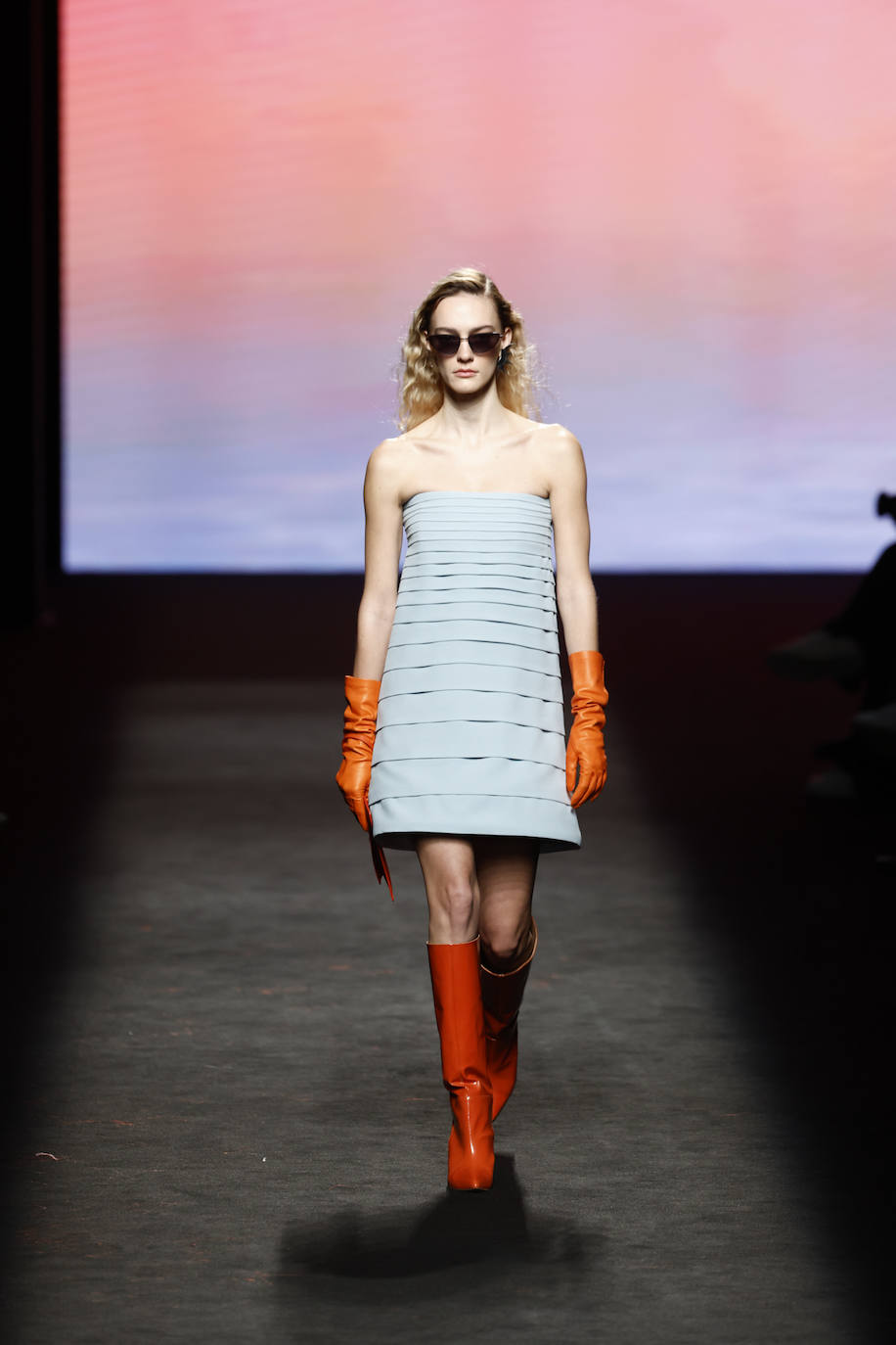 Minivestido con silueta de 'A', una de las tendencias que han presentado otros diseñadores en la pasarela madrileña. Isabel Núñez lo combina con guantes y botas altas de piel en color naranja.