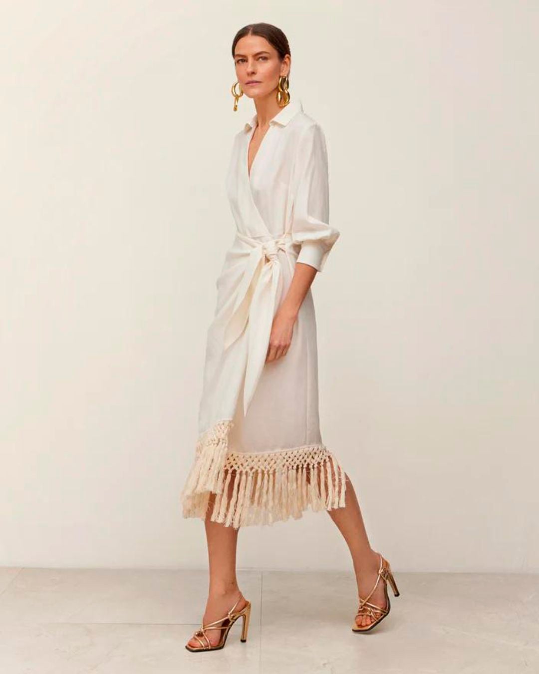 Vestido con escote cruzado en pico y falda cruzada con acabado de flecos entrecruzados. 268 euros en Simorra.