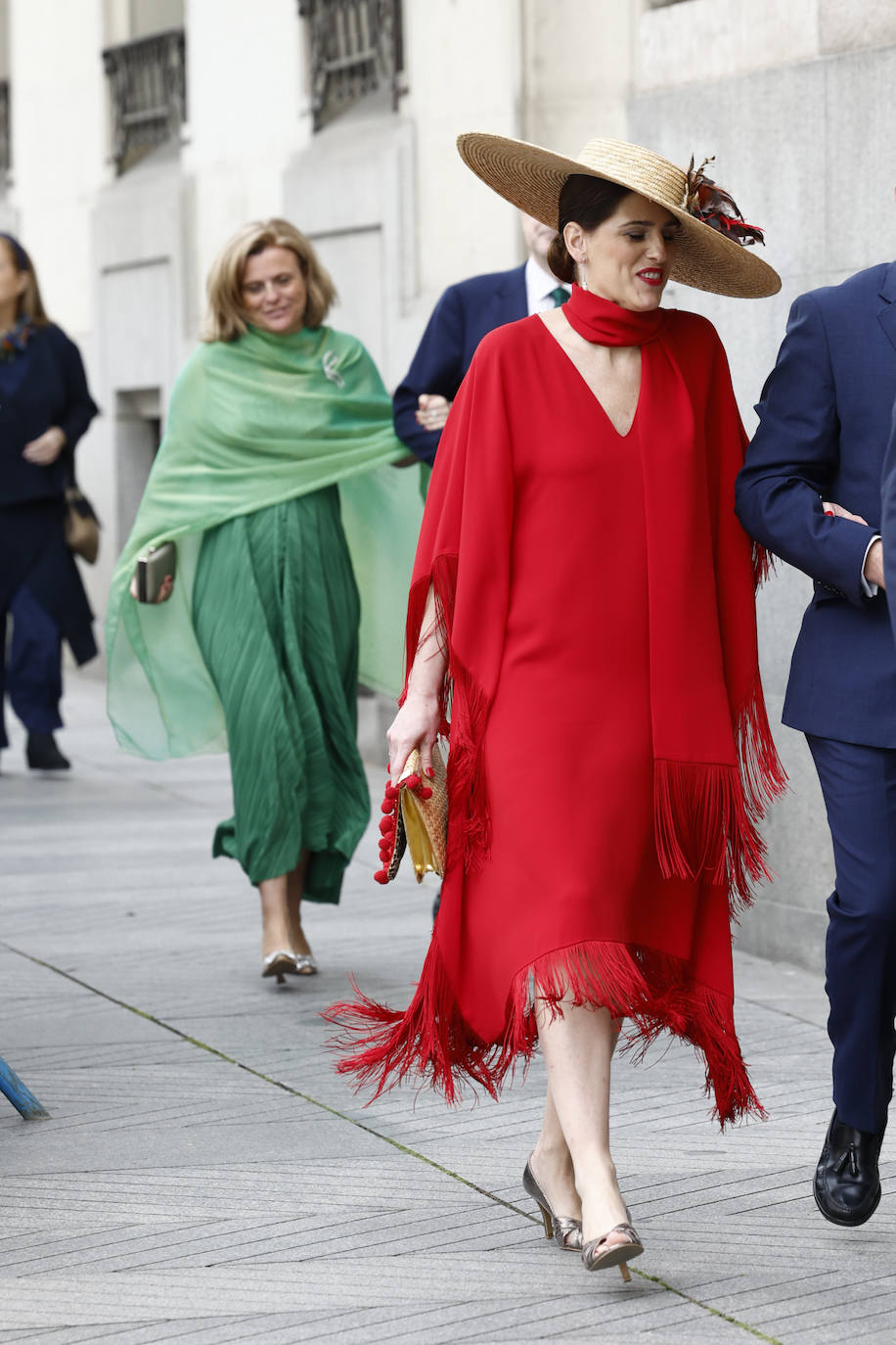 El rojo está siendo uno de los colores más repetidos entre las invitadas, en esta ocasión con detalle de flecos en el bajo, fular al cuello y pamela de rafia. 