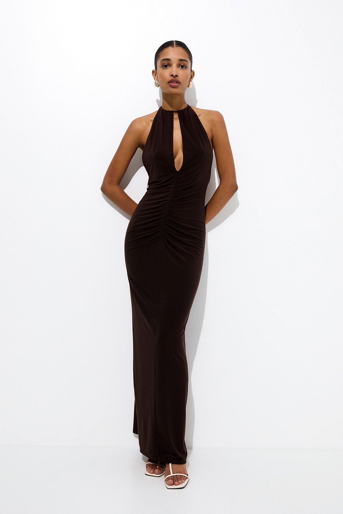 Diseño largo con escote 'halter', 'cut out' y espalda descubierta. En color marrón, ideal para combinar con accesorios dorados. 29.99 euros en Pull&Bear. 