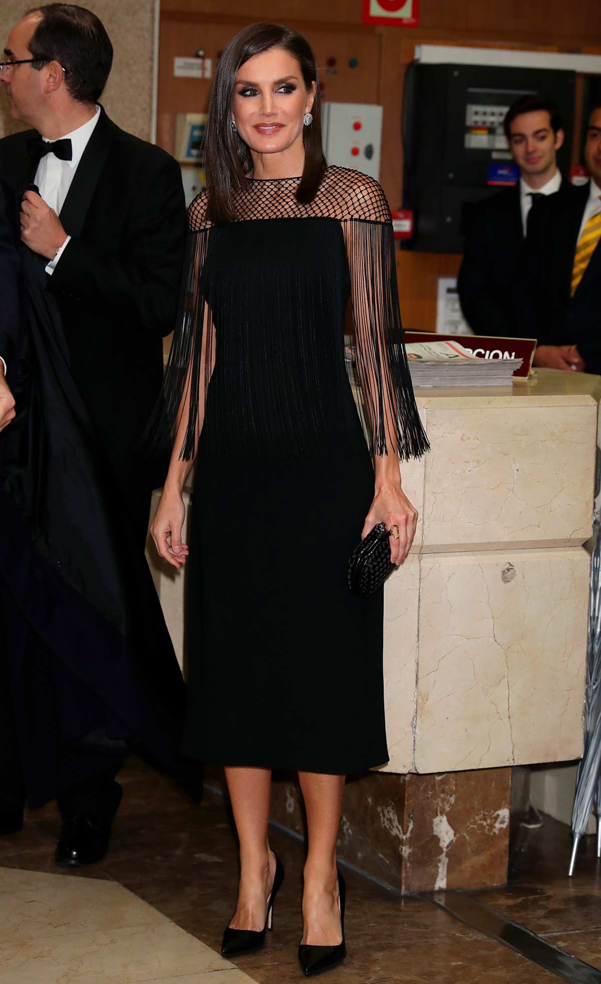 En los Premios Cavia de 2019, se decantó por un espectacular vestido negro de corte midi y repleto de flecos en la zona del escote. Firmado por Hugo Boss, lo remató con tacones de Manolo Blanhik y un bolso de mano de Bottega Veneta, ambos en color negro. 