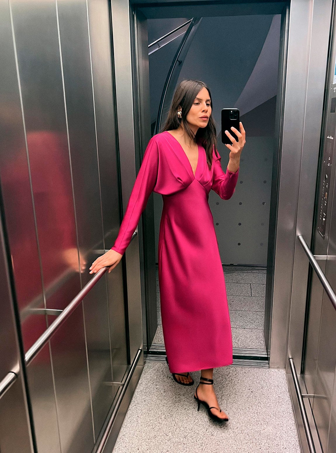 Vestido satinado de manga larga y escote en pico en color rosa. Antes, 45.95 euros en Zara. Ahora, 29.99 euros.