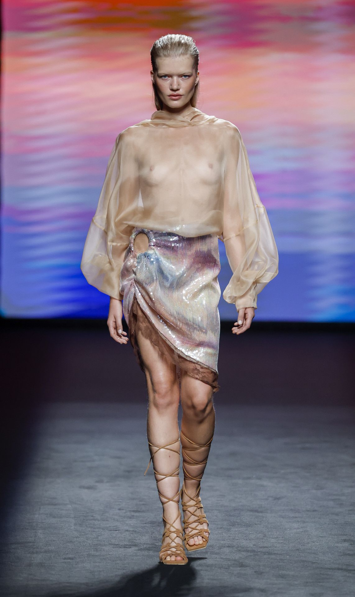 Un sofisticado conjunto de top transparente y falda asimétrica en tonos tierra, homenaje a Cantabria. 