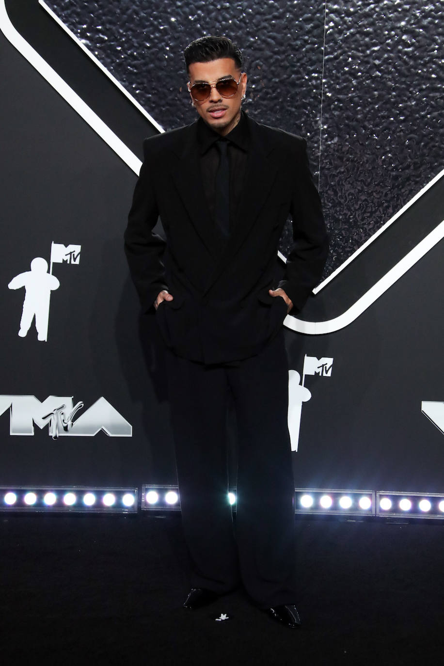 Rauw Alejandro eligió un traje negro de Saint Laurent. 