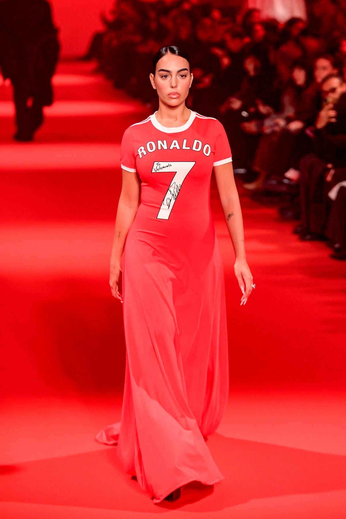 Georgina Rodríguez desfilando para Vetements en París. La empresaria debutó como modelo en la Semana de la Moda parisina con un vestido de estilo deportivo de color rojo que destacaba por su decorado en el centro, el número 7 y el apellido de su pareja, Ronaldo. 