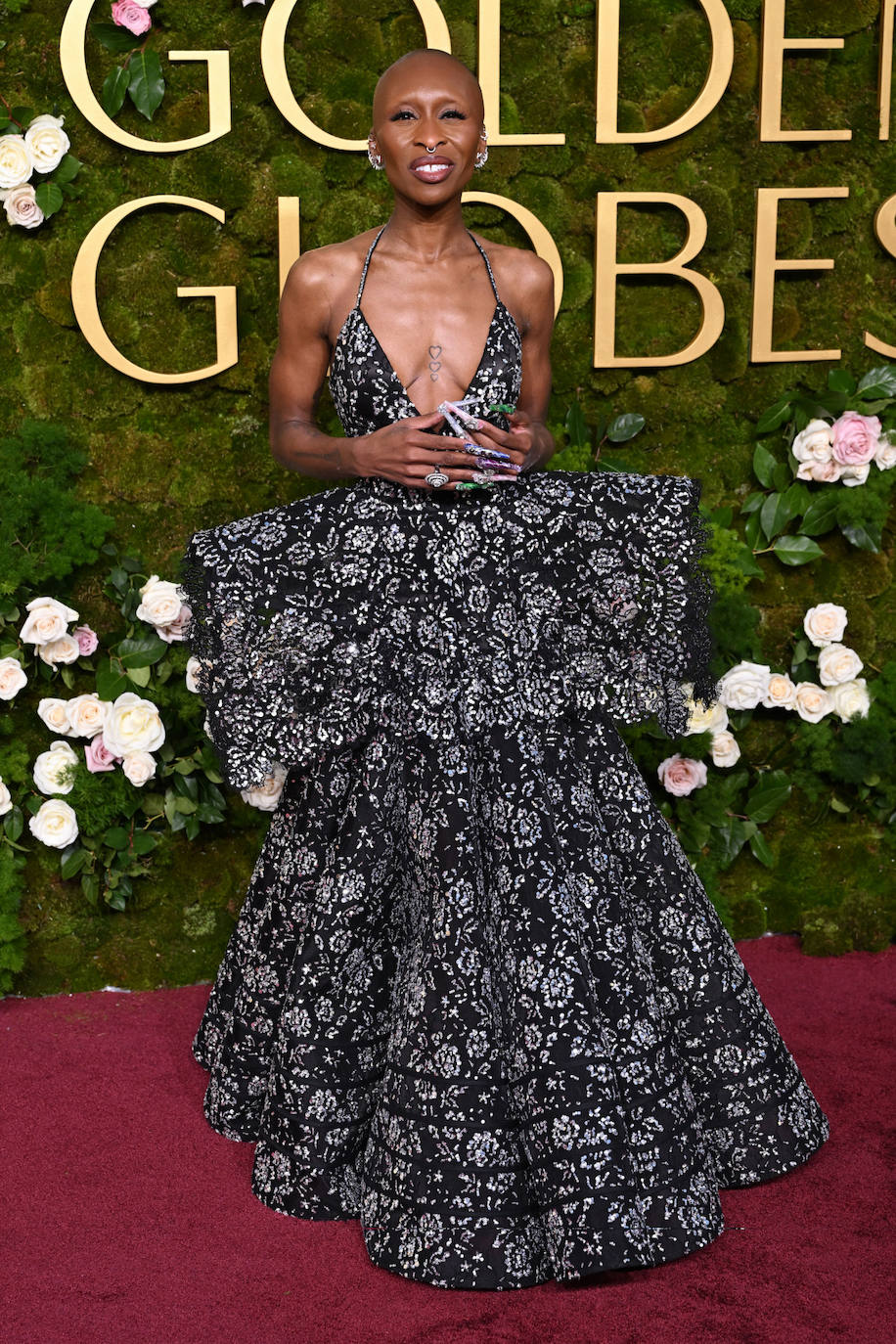 Cynthia Erivo llevó un vestido floral negro y plateado con escote pronunciado y un estructura a la altura de la cintura. Lo combinó con la manicura más extrema: uñas largas con pedrería. 