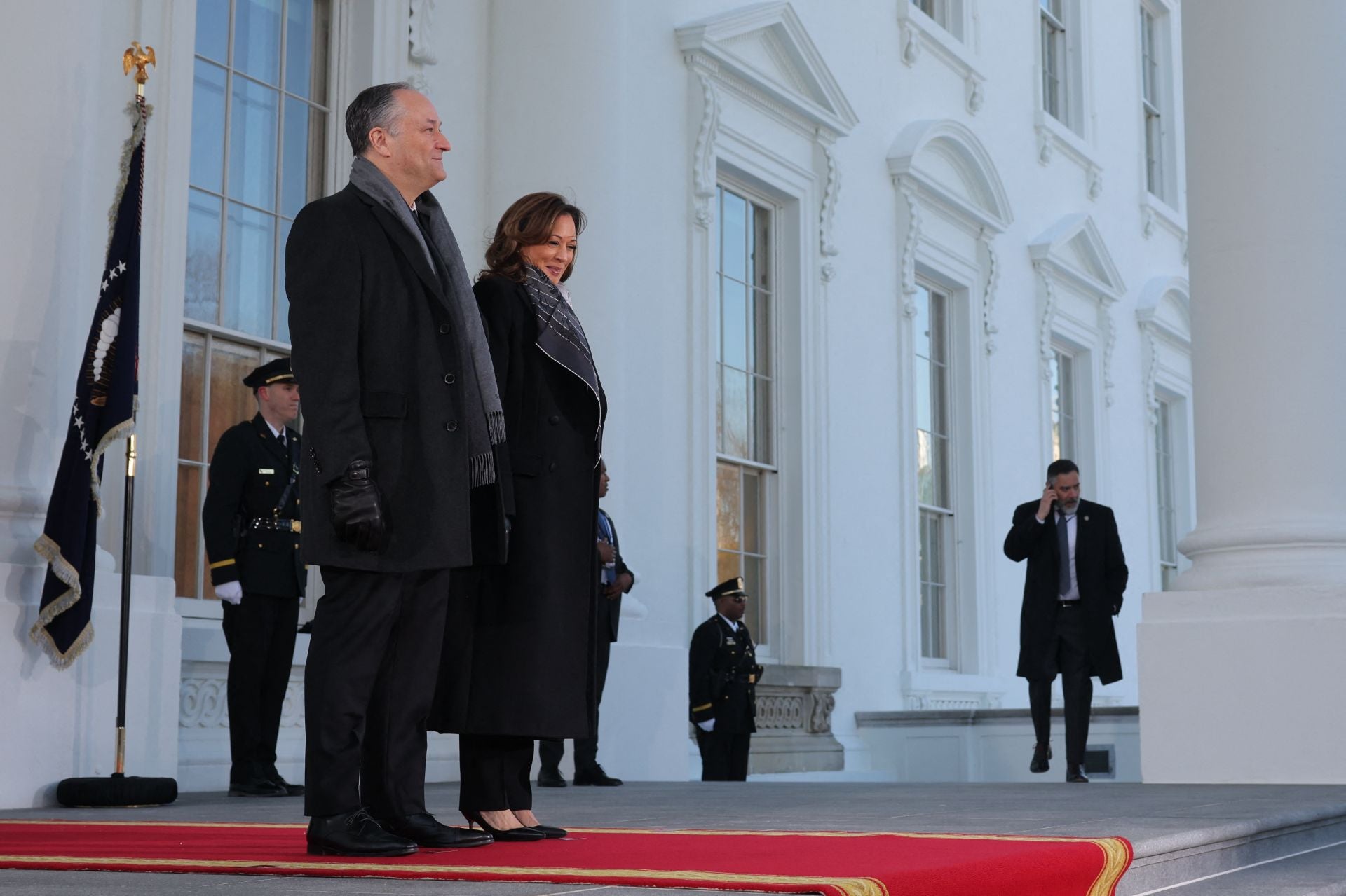 Fiel al sobrio estilo que la caracteriza, Kamala Harris hacía su aparición junto a Doug Emhoff con un look coronado por un abrigo negro, con zapatos de tacón sensato y un pañuelo estampado al cuello como único complemento.