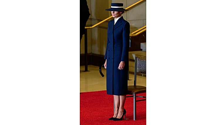 Melania Trump con abrigo sastre azul marino diseñado por el creador estadounidense Adam Lippes y el sombrero del neoyorquino Eric Javits