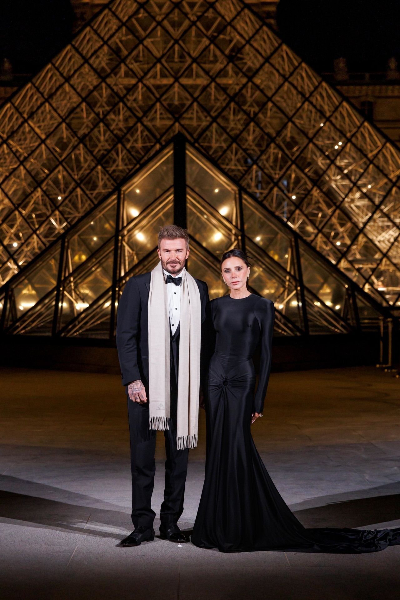 David y Victoria Beckham no se perdieron la cena del Louvre. El llevó el clásico esmoquin, ella un vestido de su colección en color negro. Se trata de un diseño largo, con cola XXL, cuello redondo, manga larga y drapeados en la cadera. Minimalista pero muy elegante. La diseñadora lo combinó con un moño y maquillaje natural. 