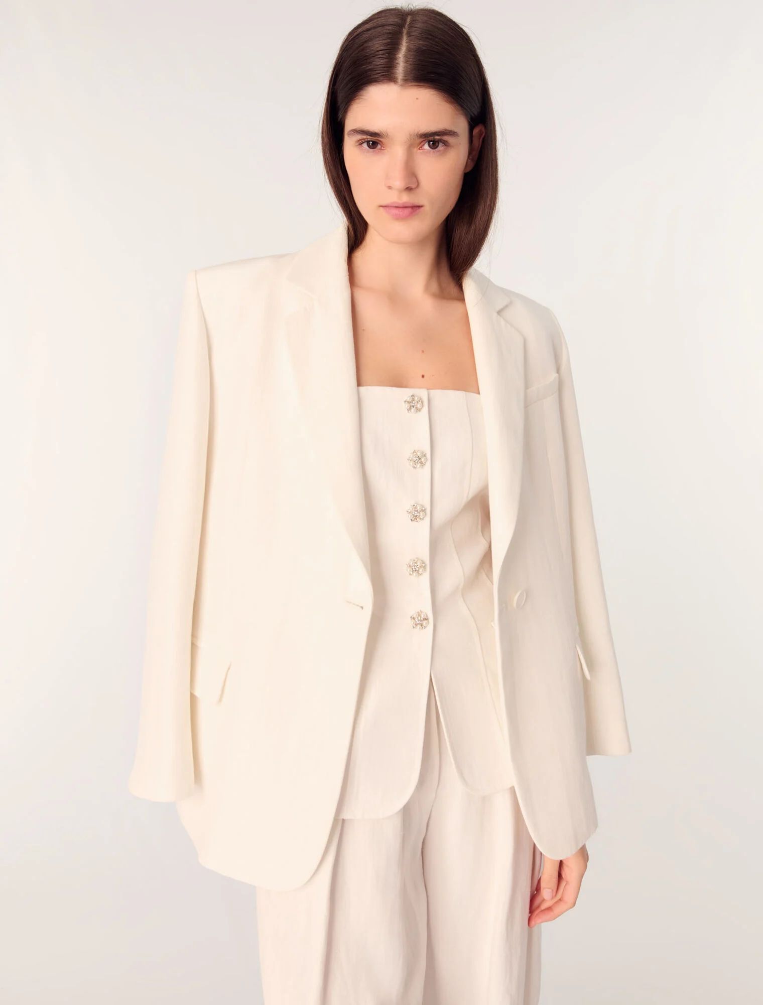 El traje con bustier es otro de los infalibles de la temporada. En Maje lo interpretan con un bustier con botones joyas, pantalón amplio y blazer tipo sastre con hombreras y un solo botón. Las tres piezas están realizadas en mezcla de lino y viscosa en Precio: blazer 395€, bustier 245€ y pantalón 235€