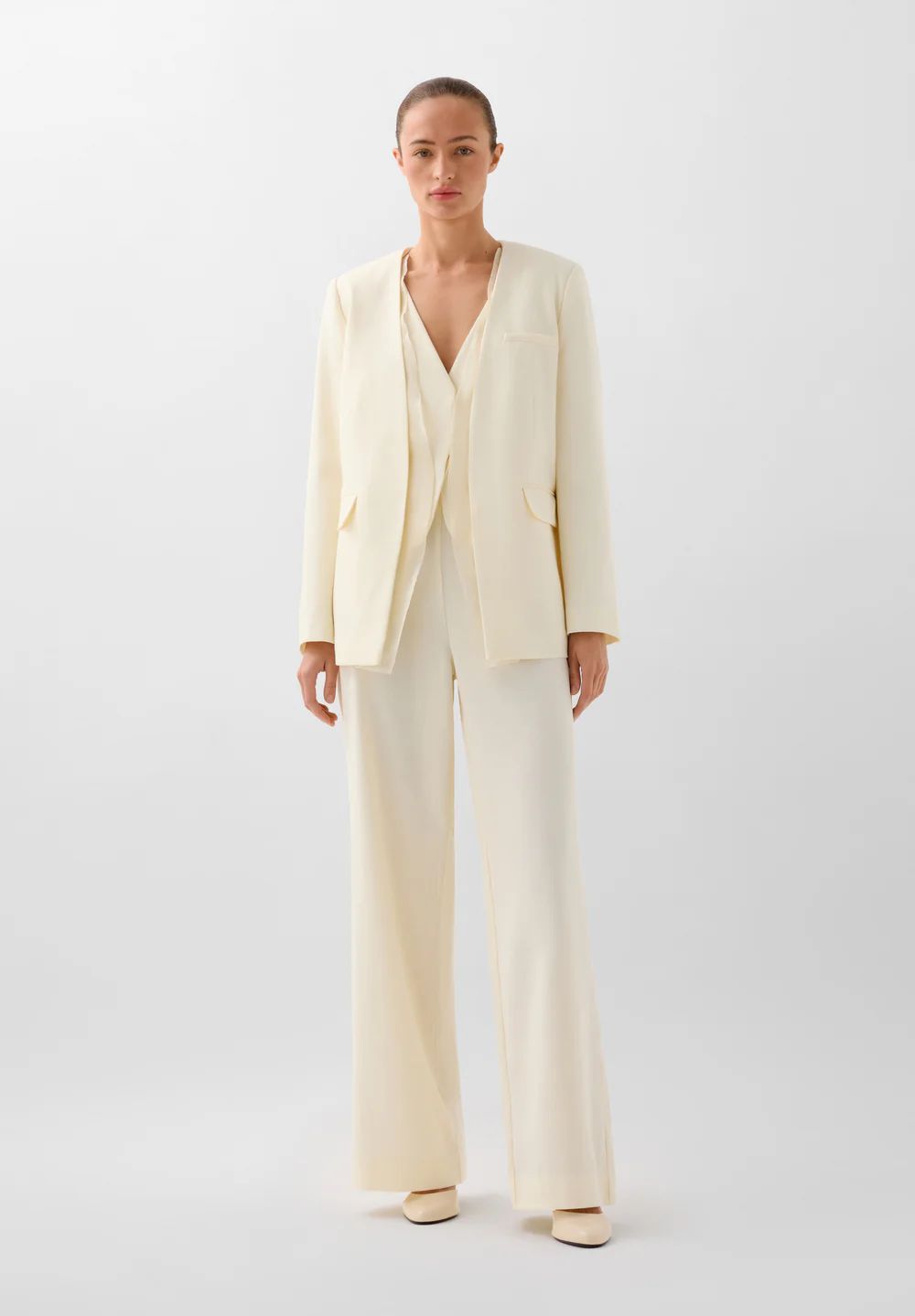 En Scalpers encontramos un aopción ideal para una celebración veraniega. En blanco roto, la blazer lisa está confeccionada en tejido fluido sin solapa y con un detalle de organza desmontable con botón interior. Se combina con un chaleco con lazo trasero y cuello en pico; y pantalón fluido con bolsillo delanteros y cierre con cremallera. Precio: blazer 149 euros, chaleco 69,90 euros y pantalón 89,90€