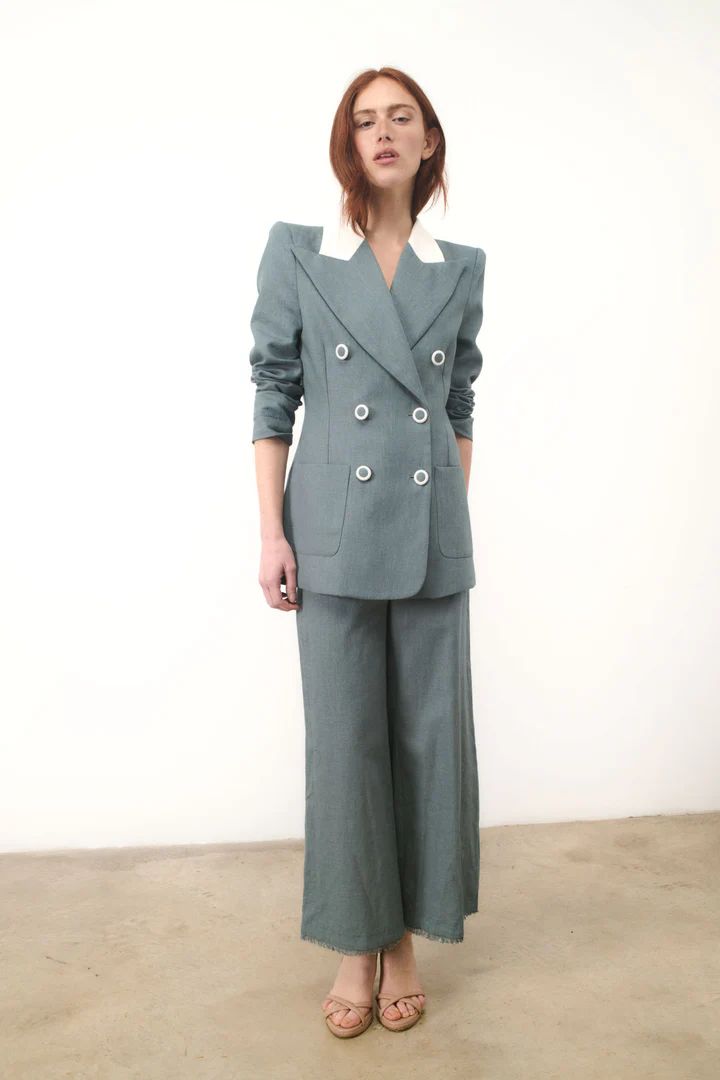 Inés Martín Alcalde prevé una primavera con muchas pinceladas de color en la que los trajes ocupan gran protagonismo. Este diseño confeccionado 100% en lino con un favorecedor azul petróleo se compone por una clásica blazer con solapa amplia, contraste en la parte del cuello, hombreras, botonadura forrada cruzada y bolsillo de cartera. Lleva fajín opcional para ajustar a la cintura y se combina con un pantalón a juego con el bajo deshilachado. Precio: blazer 318€ y pantalón 192€