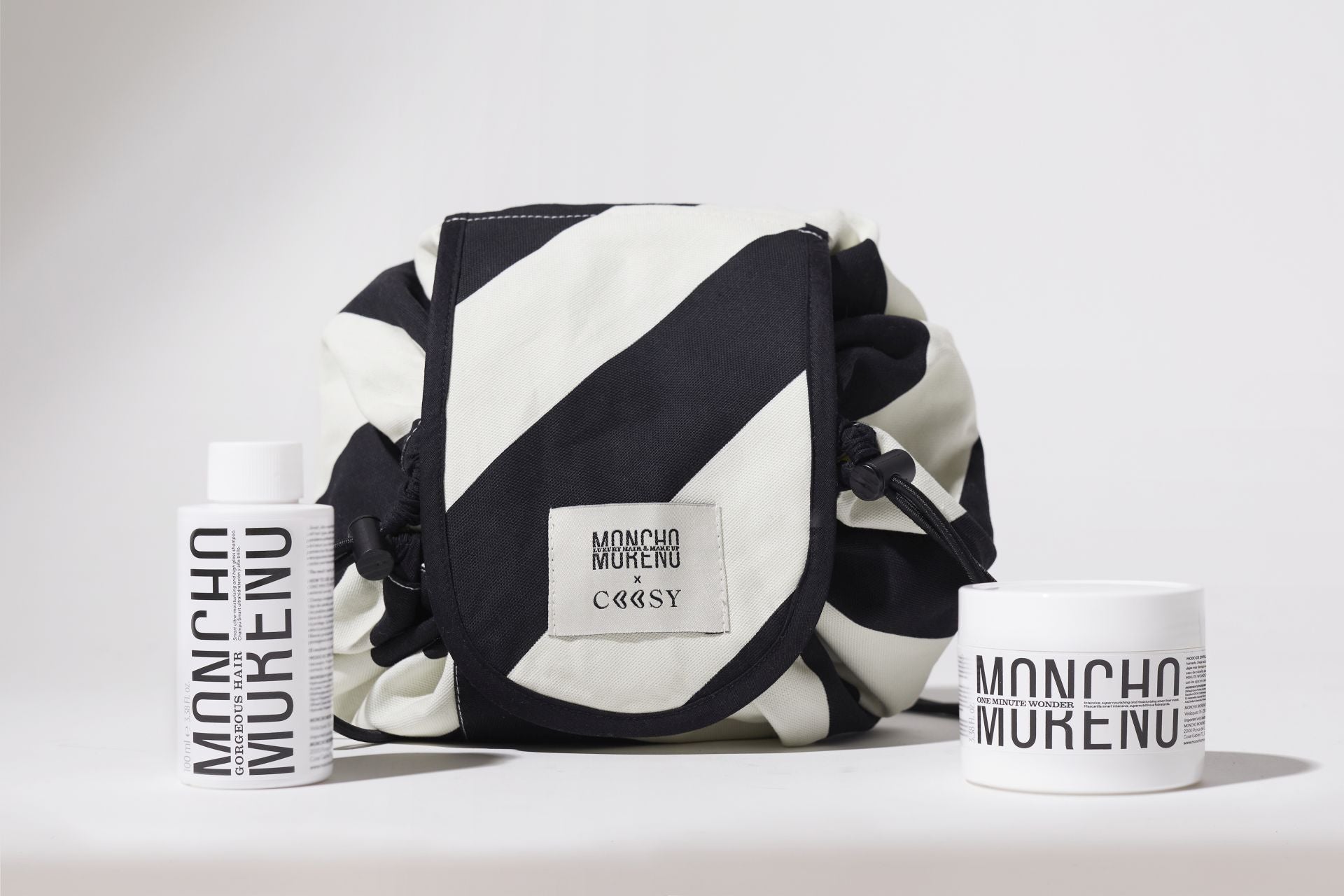 Neceser Moncho Moreno y Coosy (39,99 euros). Este exclusivo neceser de edición limitada, con tejido de rayas blanco y negro, incluye dos esenciales de la firma del peluquero Moncho Moreno en formato viaje (100 ml) para mimar el cabello: el champú Gorgeous Hair y la mascarilla One Minute Wonder.