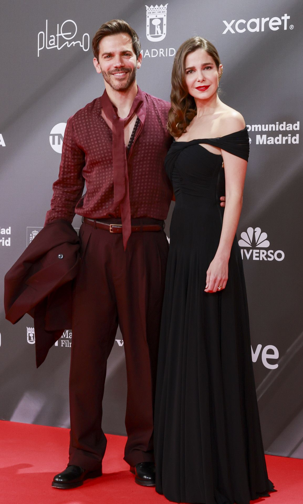 Natalia Sánchez con un vestido negro con escote off shoulder y su marido, Marc Clotet que llevó un original look en burdeos. 