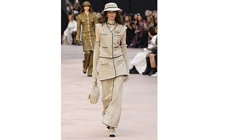 Imagen principal - Look a capas en el desfile de Chanel; abrigo con capa incorporada de Byan (345 euros) y parka XL con capucha de Stradivarius (70 euros)