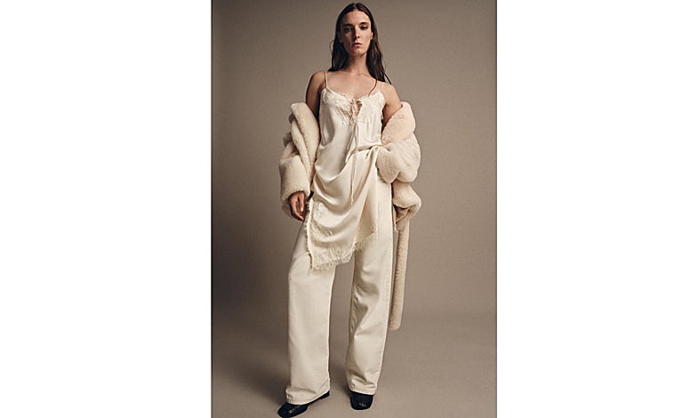 Imagen principal - Superposición de capas y mezcla de tejidos en una modelo de Zara, pantalón ejecutivo ancho de H&M en color gris (149 euros) y peto Malene con tonos burdeos de Vogana (175 euros)