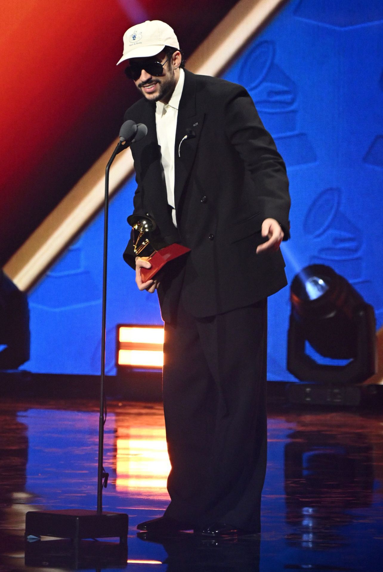 Ban Bunny no posó en la alfombra roja, pero recogió sus premios con un traje negro de estética vintage, camisa blanca y gorra blanca. 