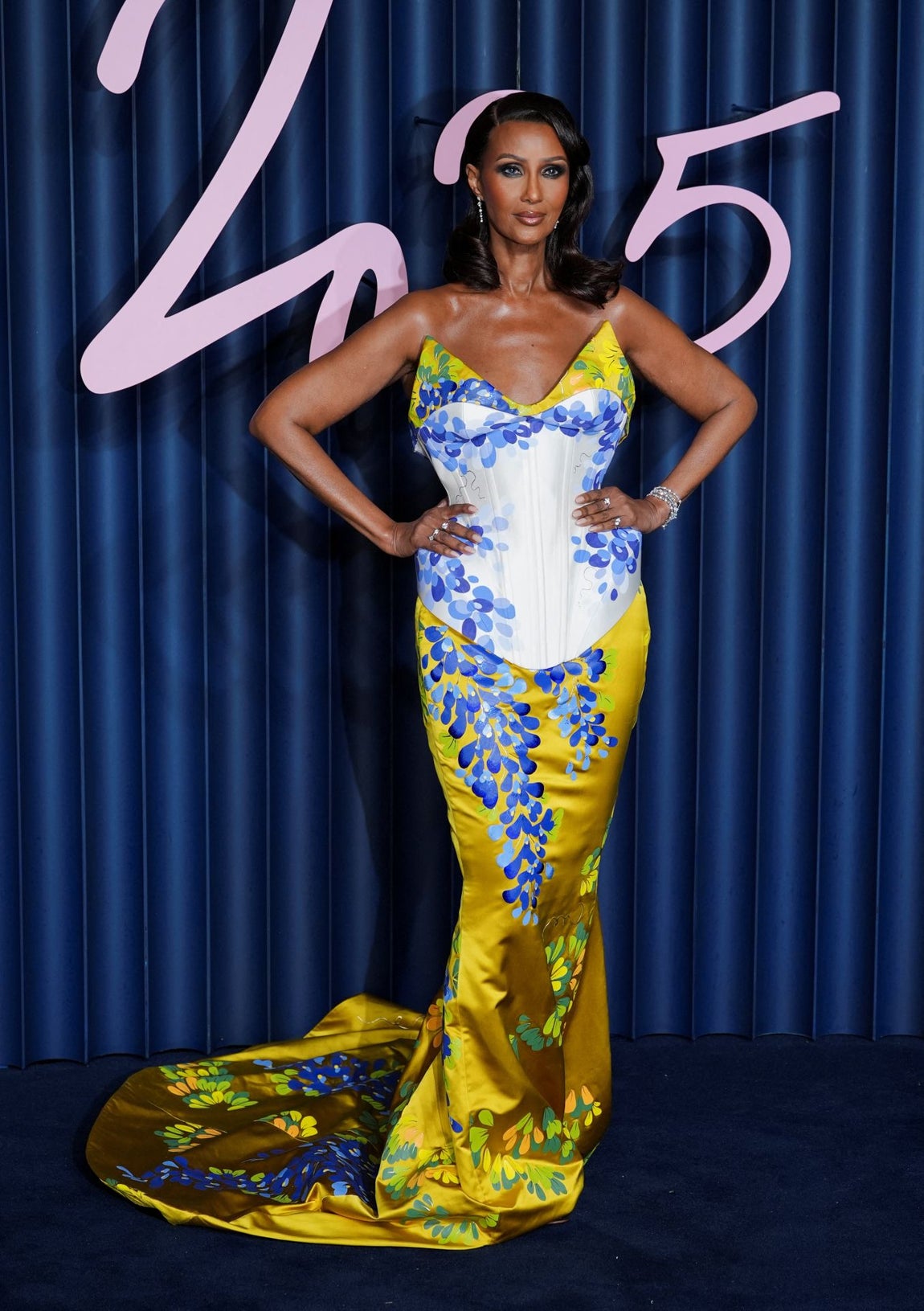 Iman fue otra de las celebrities que apostó por el color con un diseño de cuerpo encorsetado, falda de sirena y  estampado floral, de Harris Reed (colección Primavera/Verano 2026).