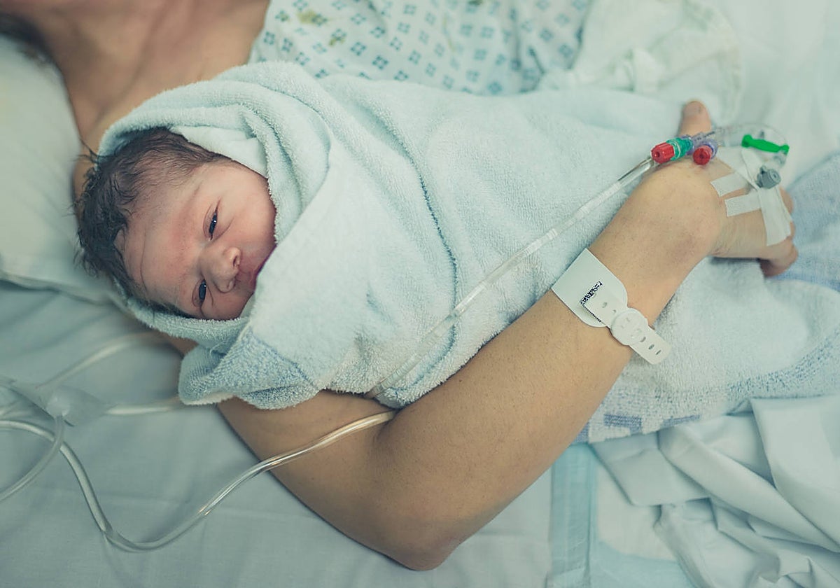 Una mujer sostiene a su bebé recién nacido en el hospital