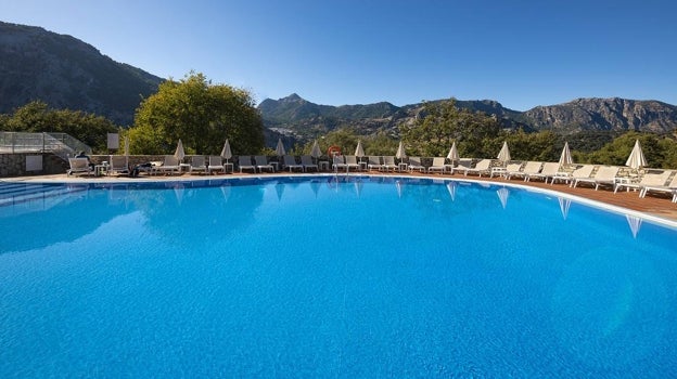 Vista de la piscina desde donde se puede observar un bonito paisaje montañoso