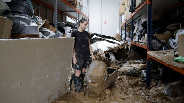 La propietaria de una fábrica de carritos de bebé observa desolada el estado de su establecimiento junto al Barrancal del Poyo, en Torrent