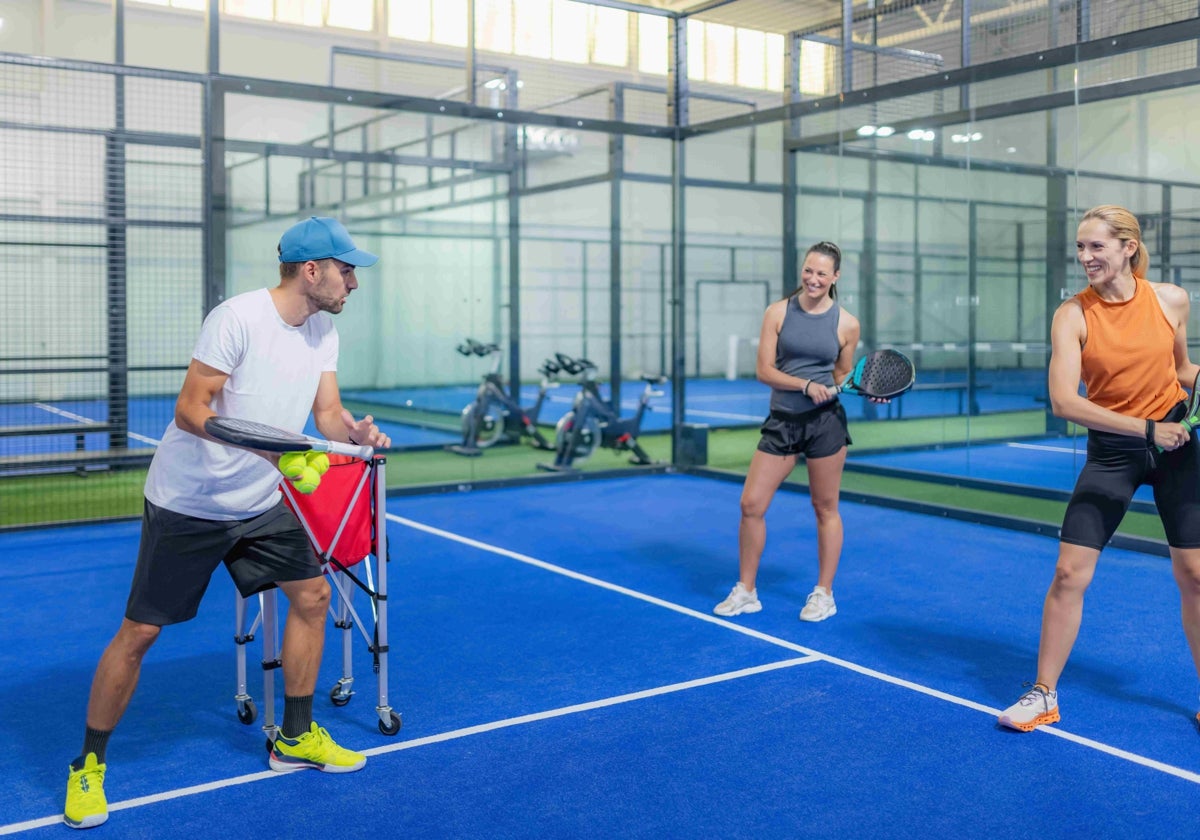 Dos jugadoras de pádel entrenan en una pista cubierta