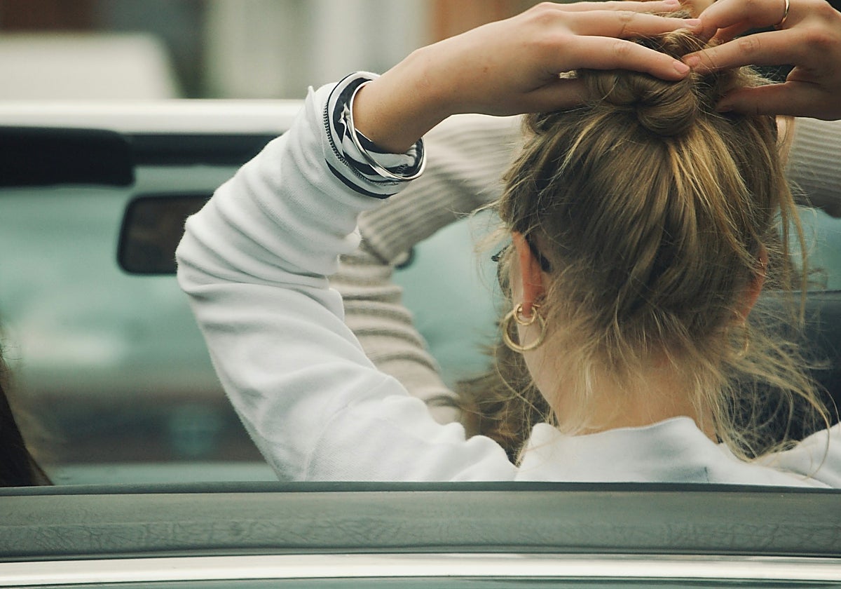 Una chica se recoge la melena en un coche