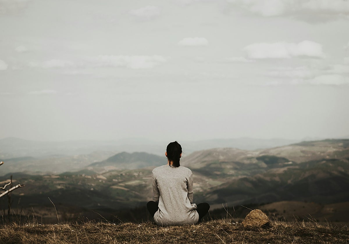 Mujer sentada mirando al horizonte.