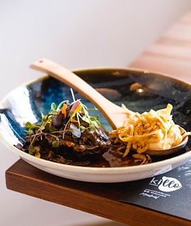 Imagen secundaria 2 - Arriba, barra alta de Killo con vistas a la cocina. Abajo, sus croquetas de coliflor y la carrillada de vaca vieja con crema y crujiente de chirivía