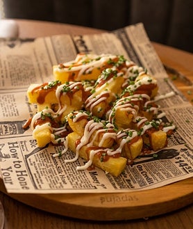 Imagen secundaria 2 - Arriba, guiso de callos con huevo frito en La Barra de la Reme. Abajo, su croqueta de pote gallego y las 'bravas muy bravas' que sirve este nuevo espacio del barrio de Salamanca